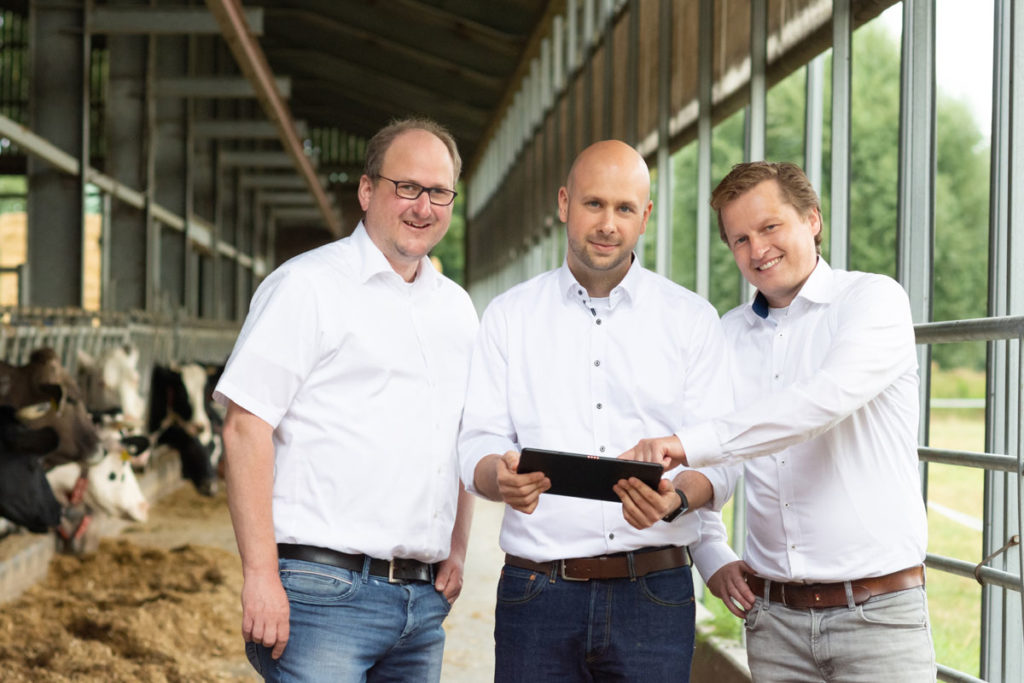 Das Team von FlexFleet mit Tablet im Kuhstall